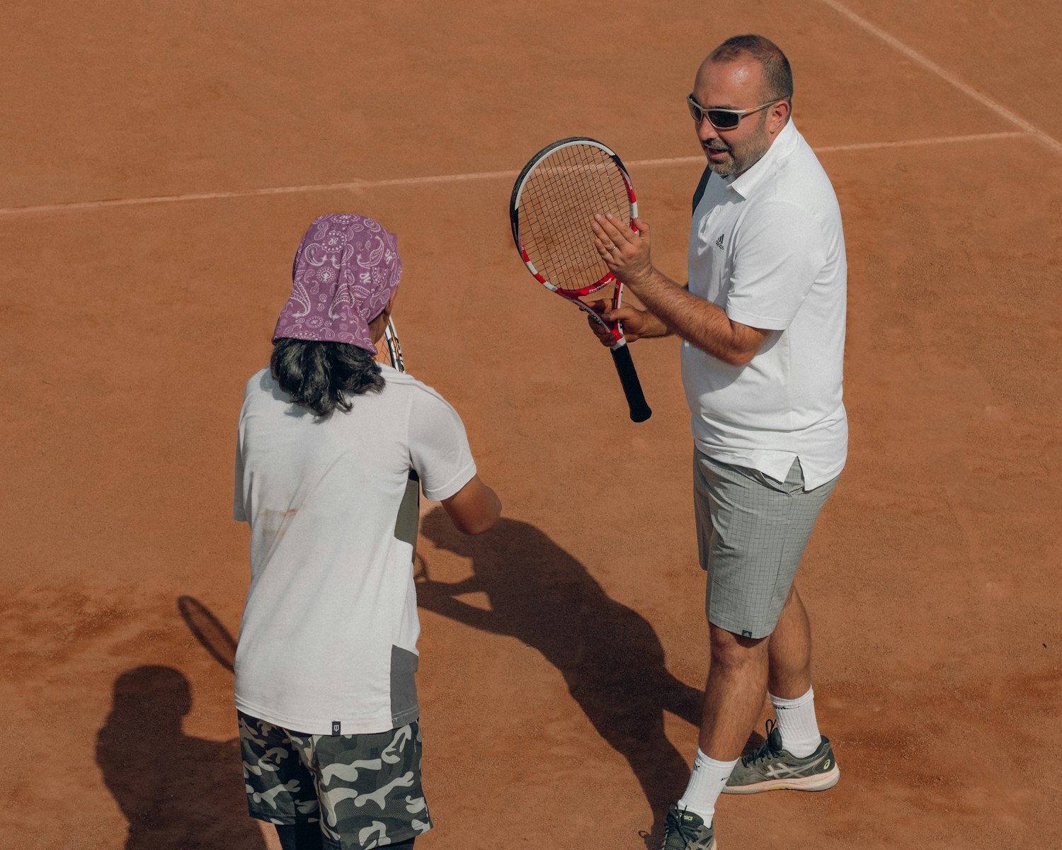 A coach smiling with a player on court
